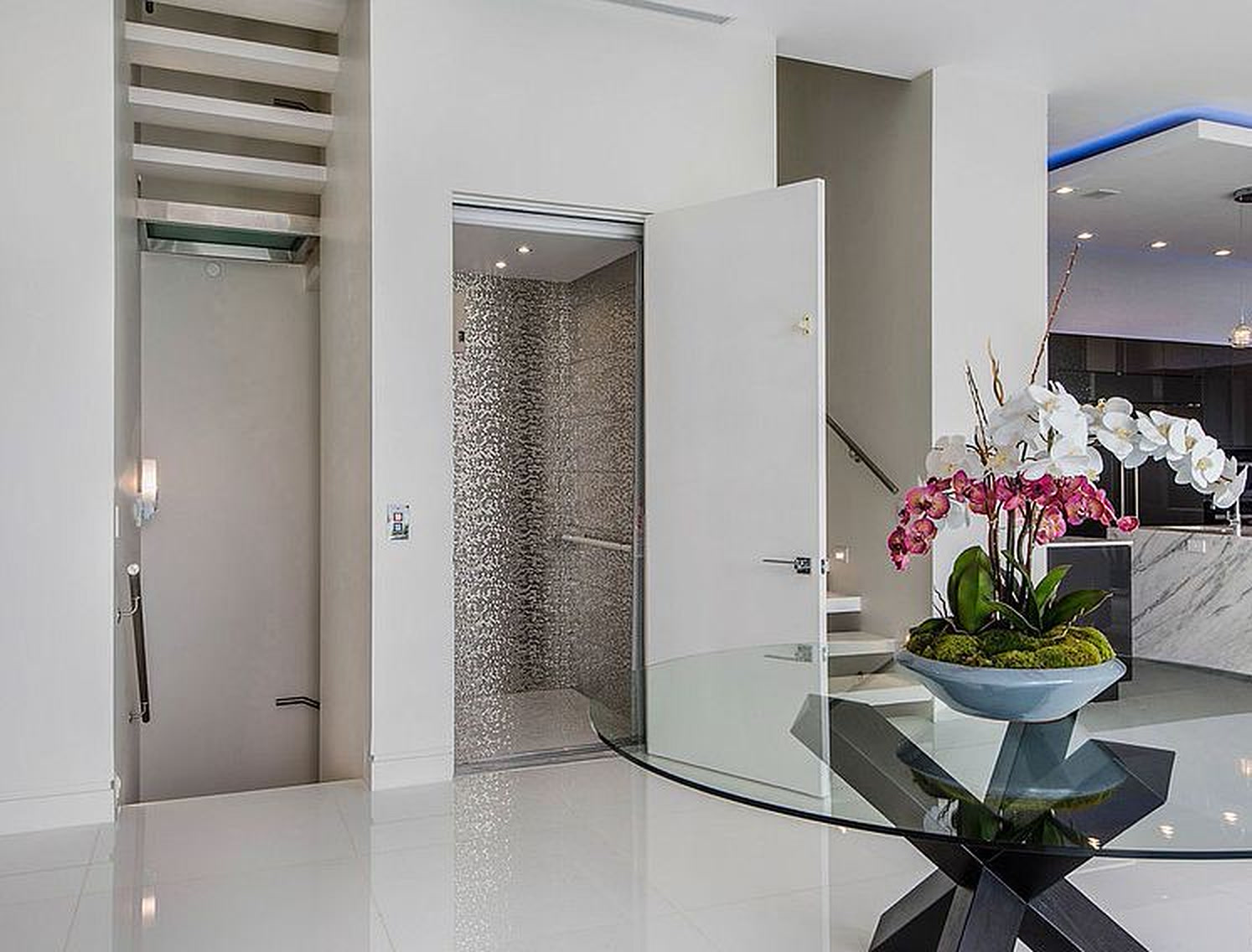 Bel Air entry hall with glass elevator, mosaic tile and floating stair