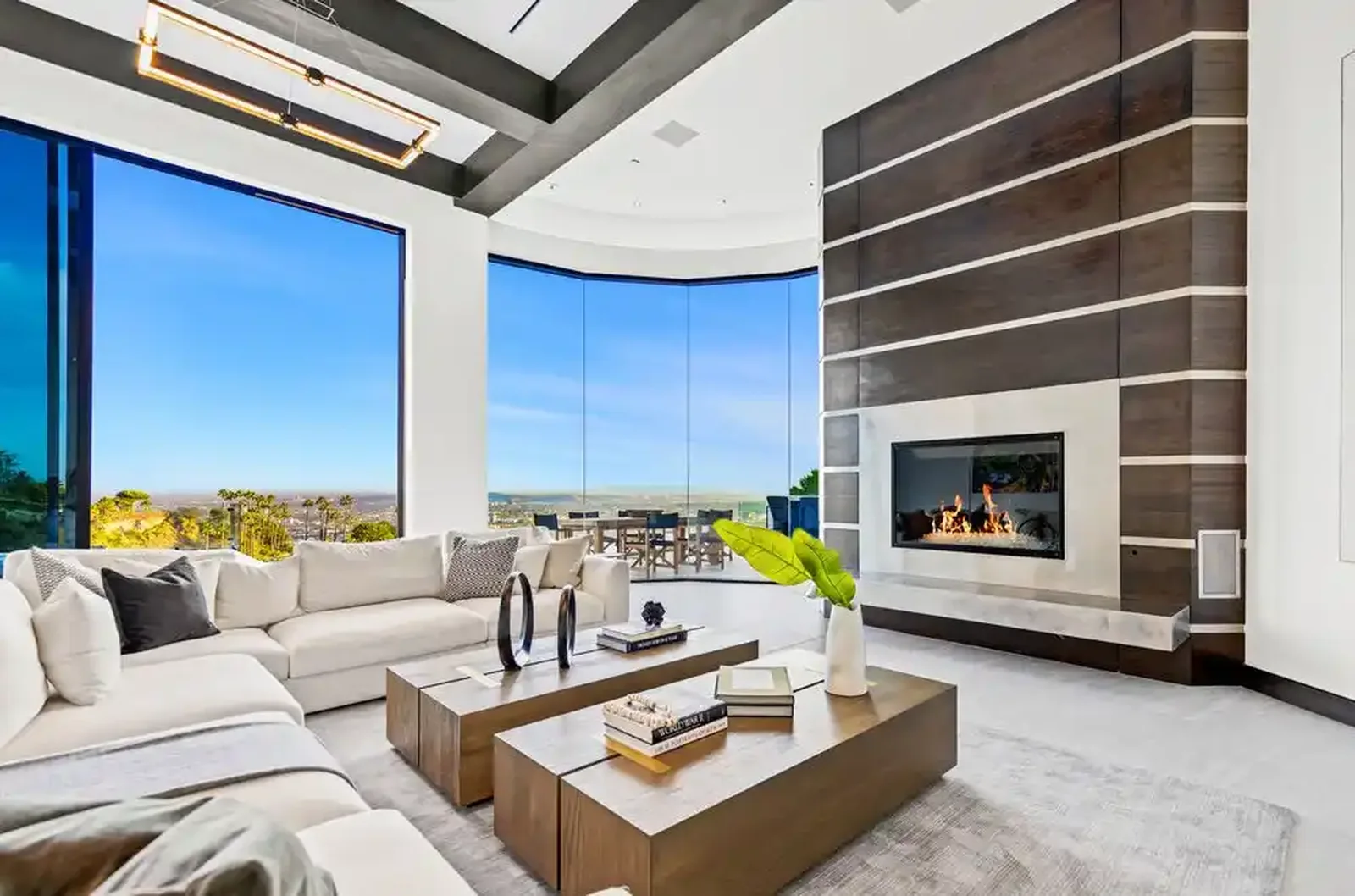 Living room with linear fireplace, built-in shelving and city views