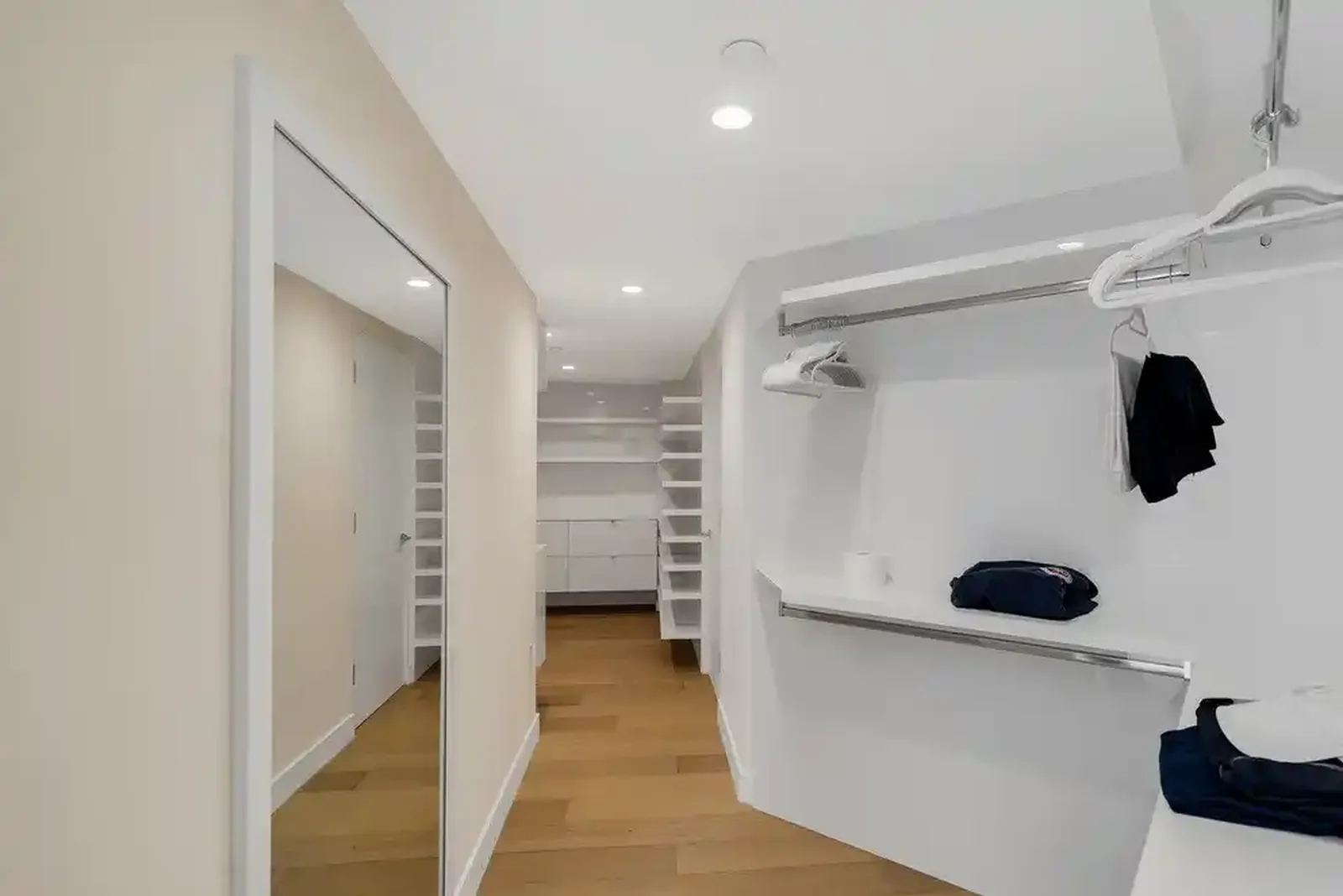 Walk-in closet with custom white cabinetry
