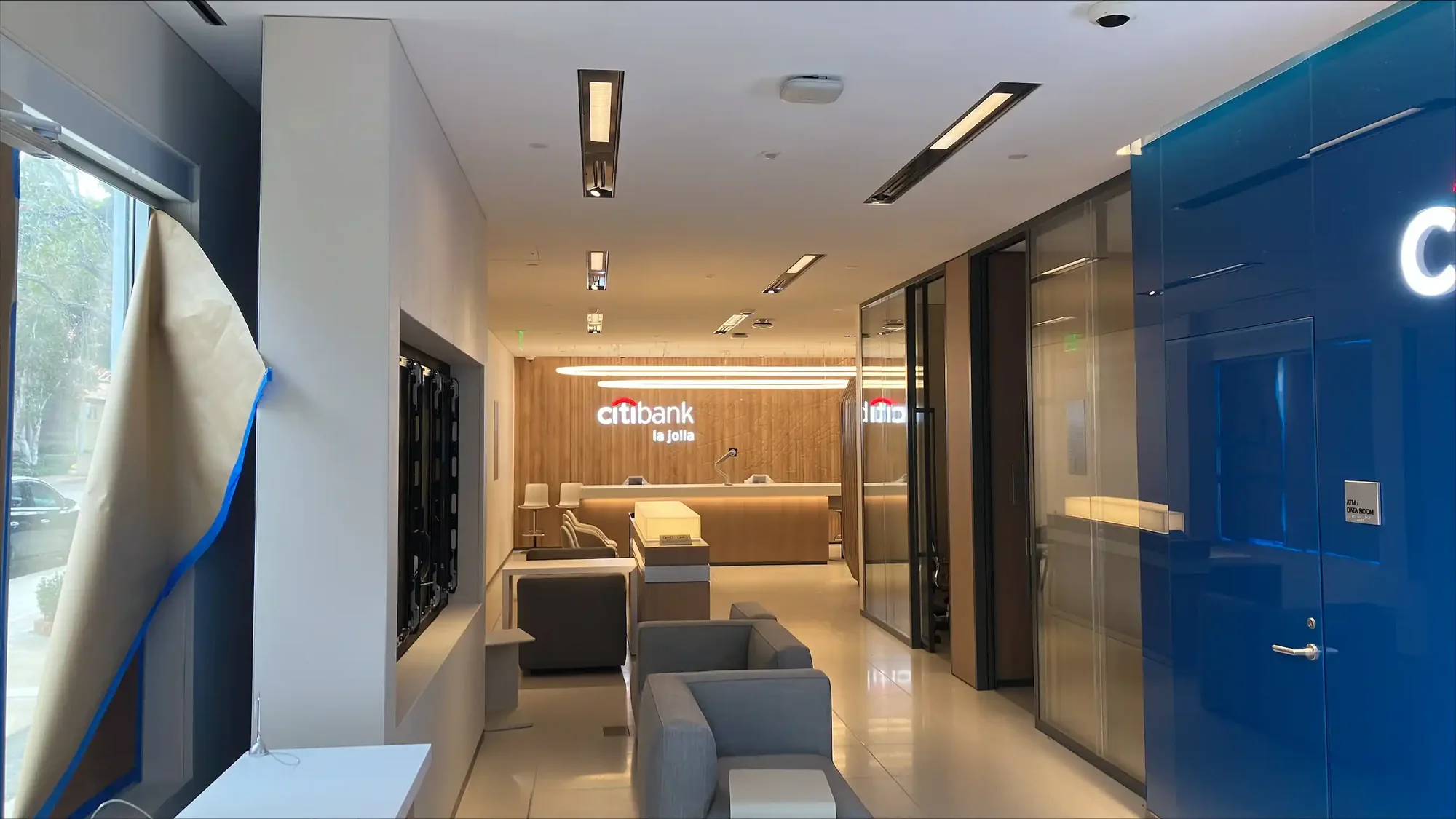 Bank branch corridor with lounge seating and brand wall