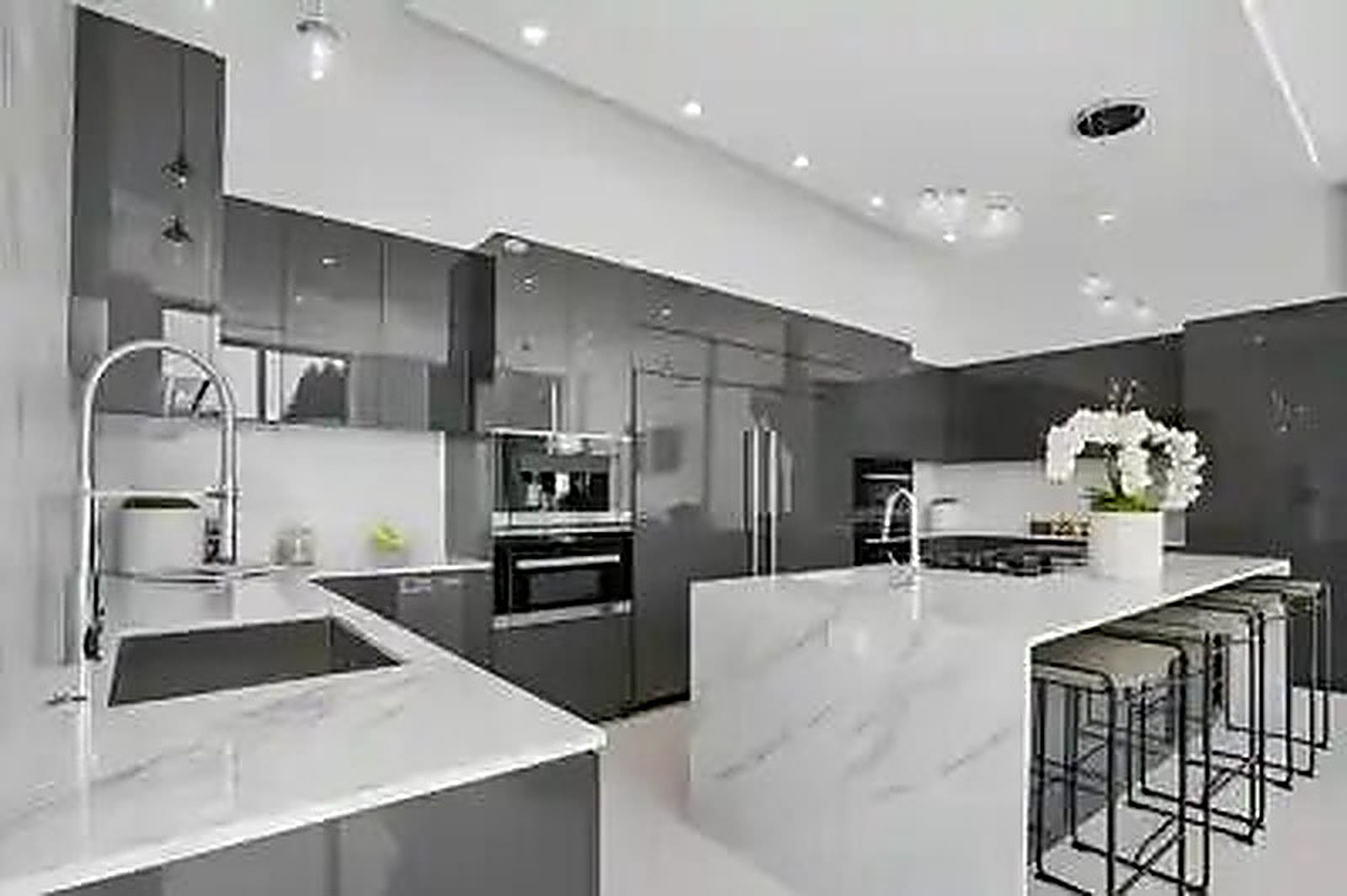 Marble kitchen with waterfall island and integrated appliance wall