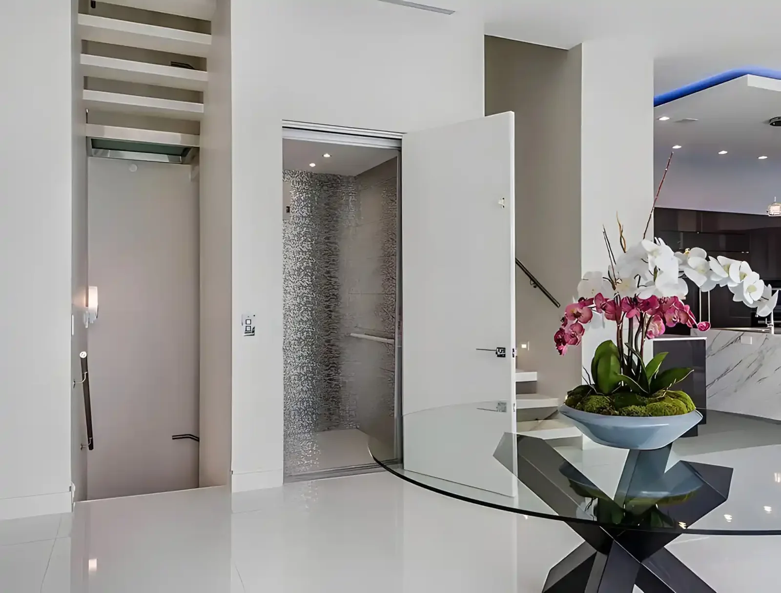 Glass entry vestibule with stone flooring and floral display