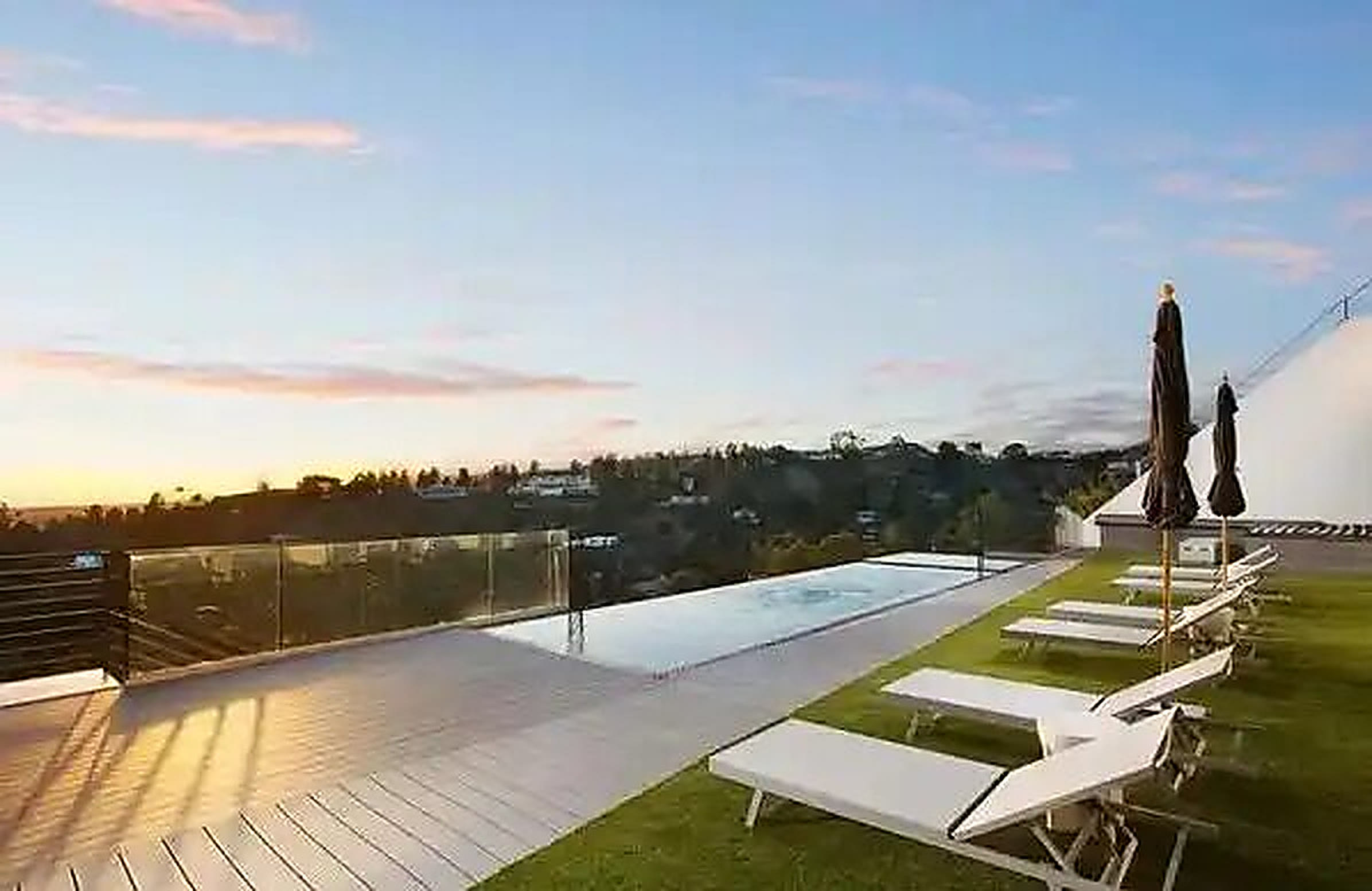 Rear yard pool deck at sunset after a full exterior remodel