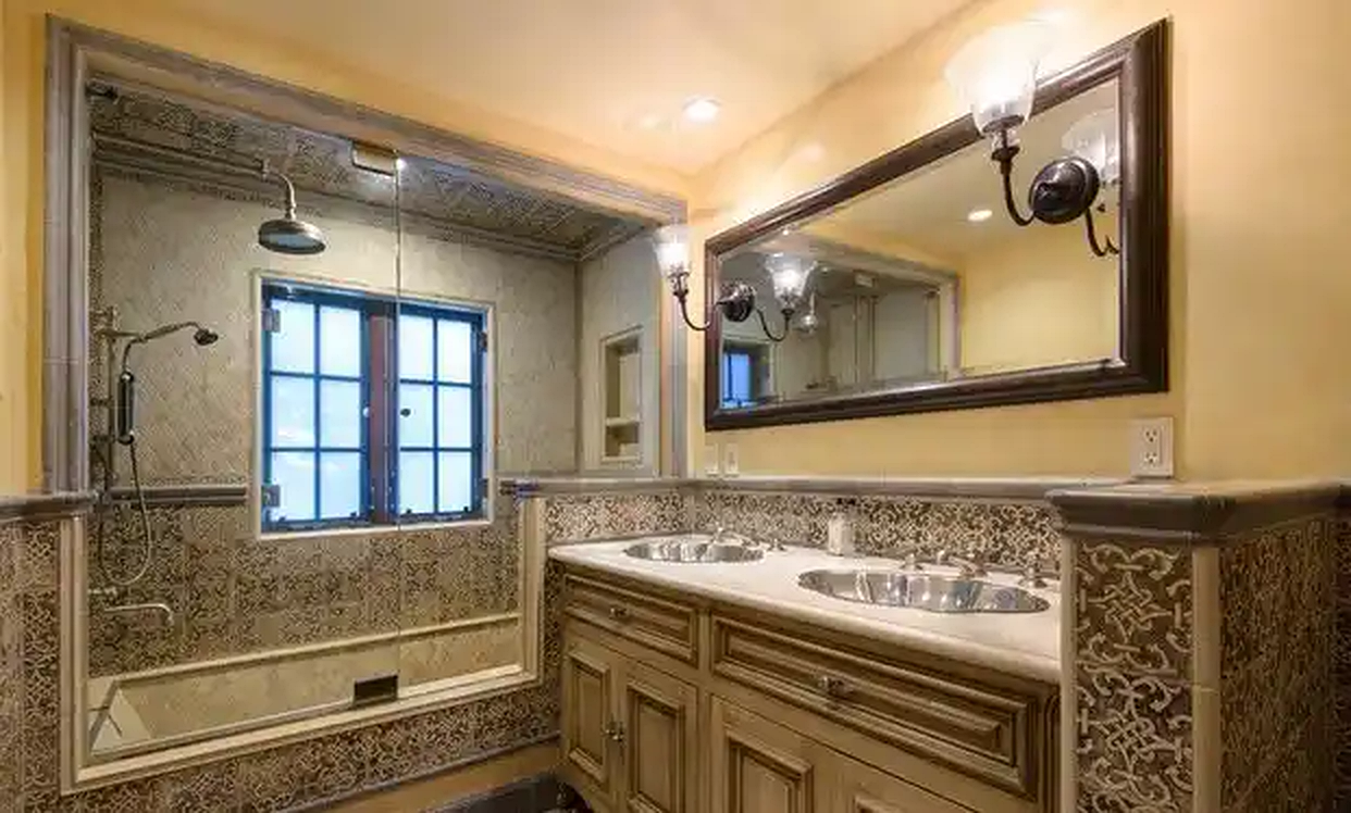 Torreyson bathroom with stone vanity and framed mirror
